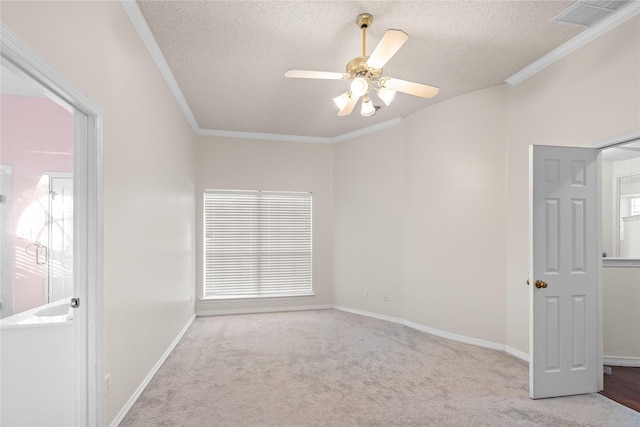 carpeted empty room with a textured ceiling, crown molding, and ceiling fan