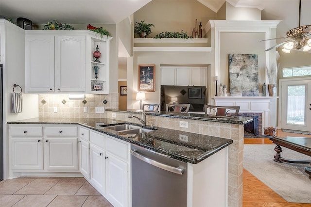 kitchen featuring sink, stainless steel dishwasher, white cabinets, and kitchen peninsula