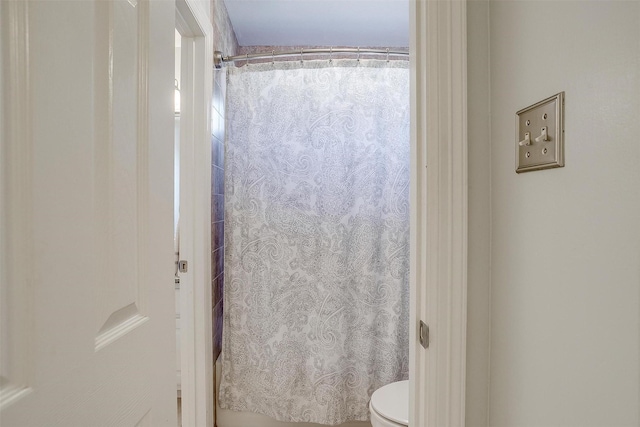 bathroom featuring a shower with shower curtain and toilet