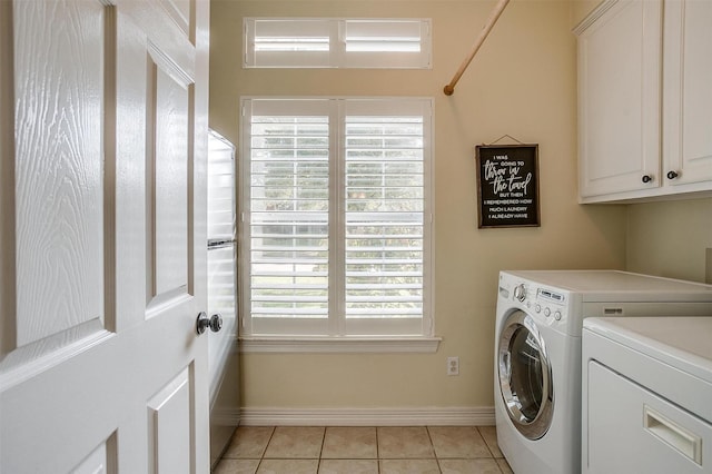 clothes washing area featuring separate washer and dryer, cabinets, and light tile patterned flooring