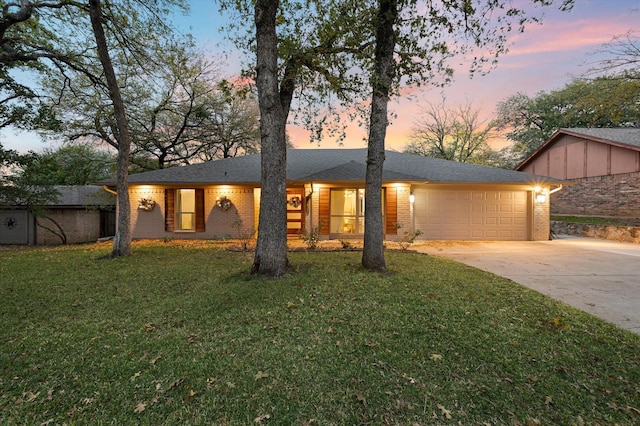 single story home featuring a garage and a yard