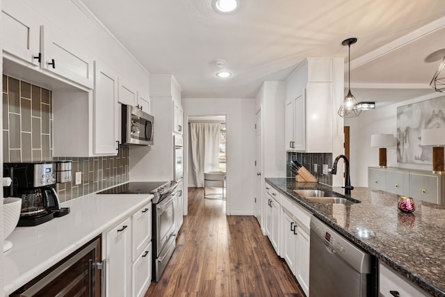 kitchen with wine cooler, sink, white cabinetry, hanging light fixtures, and appliances with stainless steel finishes