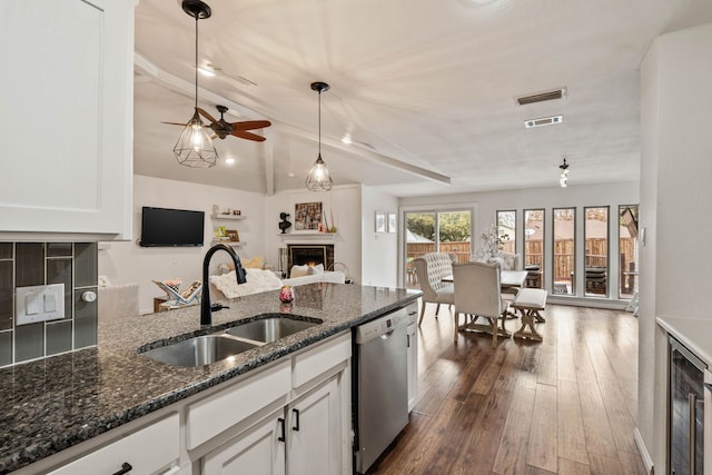 kitchen featuring white cabinetry, dark stone counters, dishwasher, and sink