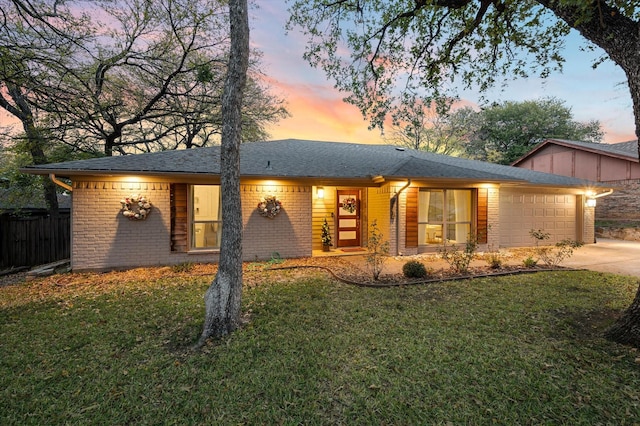 single story home featuring a garage and a yard