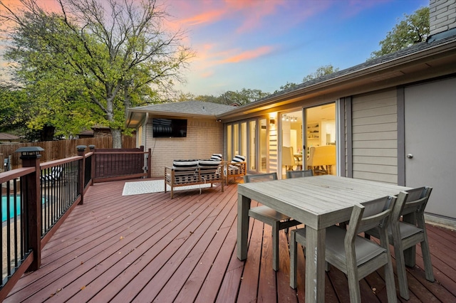 deck at dusk with an outdoor hangout area