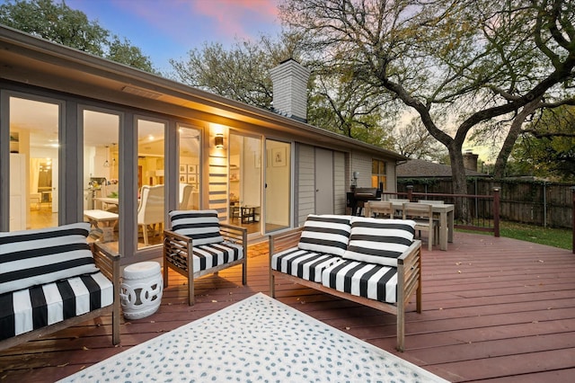 deck at dusk featuring outdoor lounge area