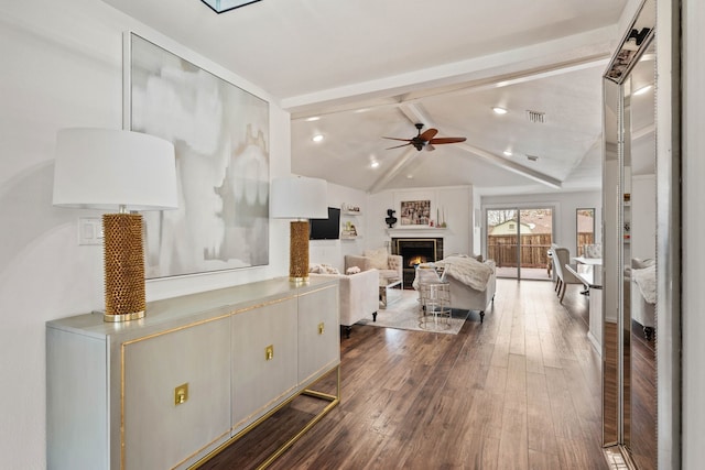 living room featuring lofted ceiling with beams, dark hardwood / wood-style floors, and ceiling fan