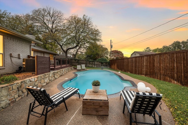 pool at dusk featuring a patio