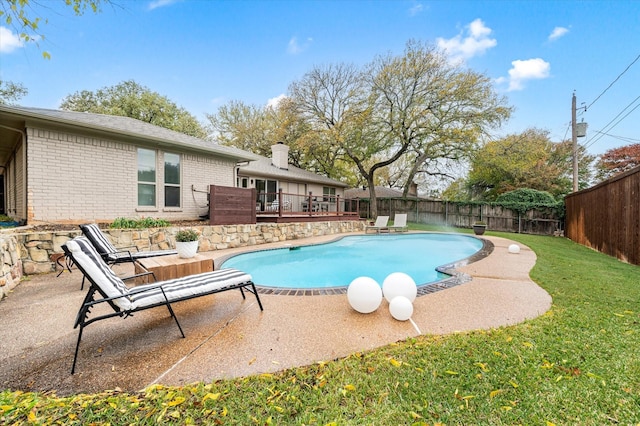 view of pool featuring a deck and a lawn