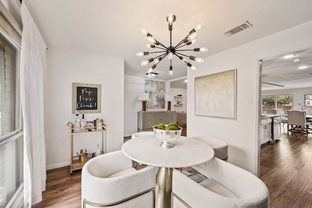 dining room with dark hardwood / wood-style floors and a notable chandelier