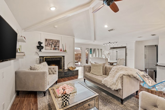 living room featuring a fireplace, lofted ceiling with beams, dark hardwood / wood-style floors, and ceiling fan