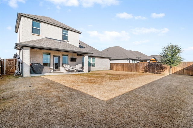 rear view of property featuring a yard and a patio area