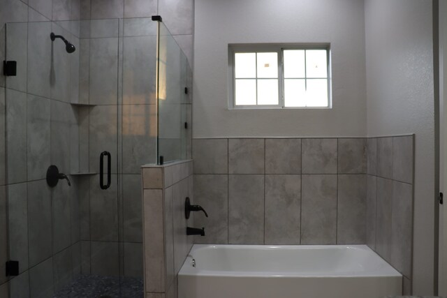 bathroom with wood-type flooring, shower with separate bathtub, and toilet