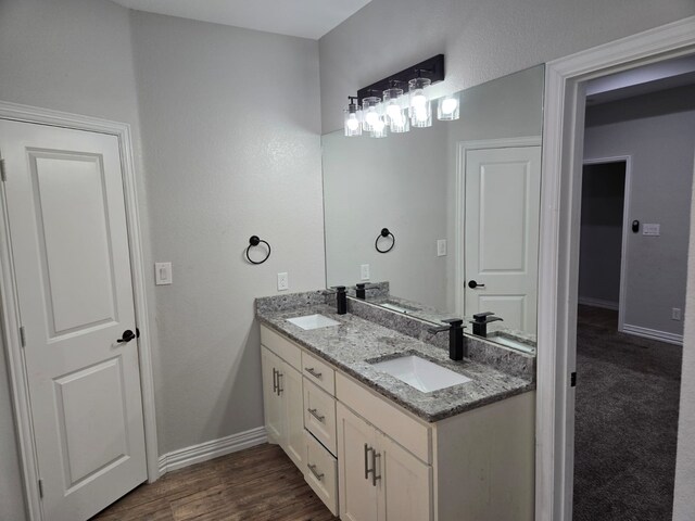 full bathroom featuring vanity, hardwood / wood-style flooring, tiled shower / bath combo, and toilet