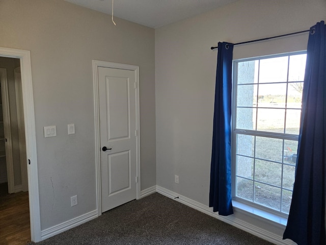 spare room with dark carpet