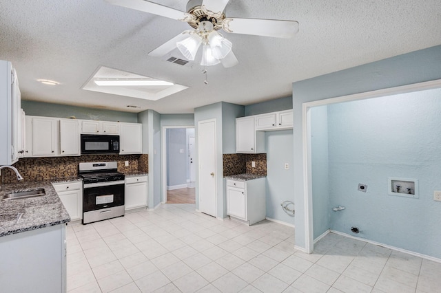 kitchen with sink, gas range, tasteful backsplash, dark stone countertops, and white cabinets