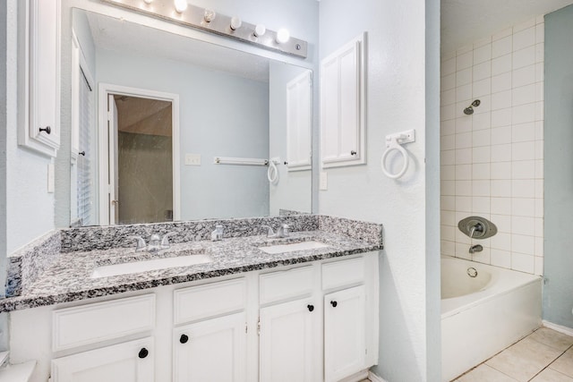 bathroom featuring tiled shower / bath, tile patterned floors, and vanity