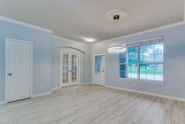 unfurnished room featuring french doors, crown molding, and light wood-type flooring