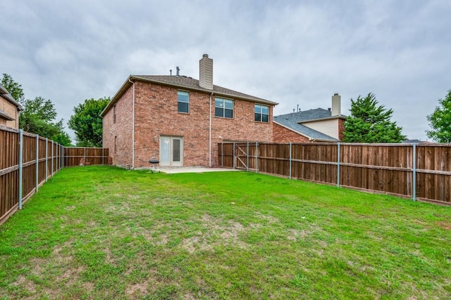 rear view of property with a yard and a patio area