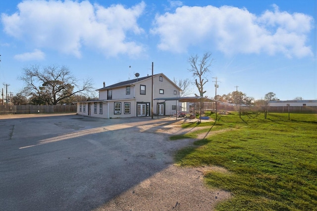 view of front of house featuring fence and a front lawn