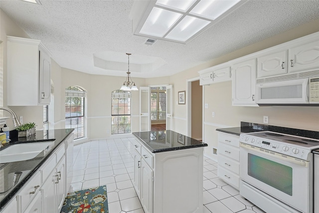 kitchen featuring white cabinetry, sink, white appliances, and a tray ceiling