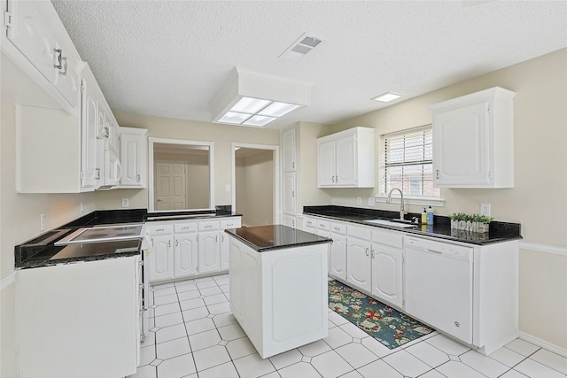 kitchen featuring white cabinetry, white appliances, sink, and a kitchen island