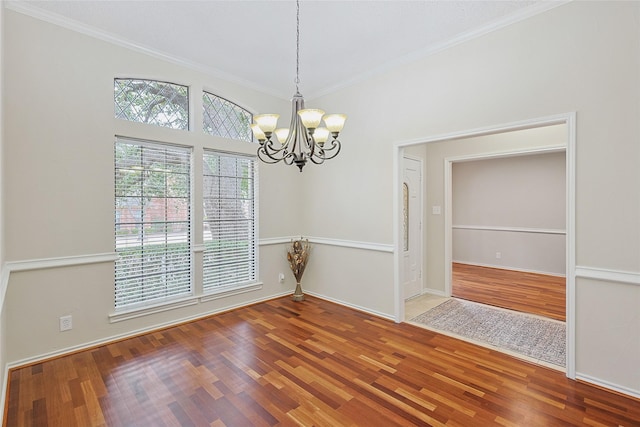 spare room with crown molding, a chandelier, and hardwood / wood-style floors