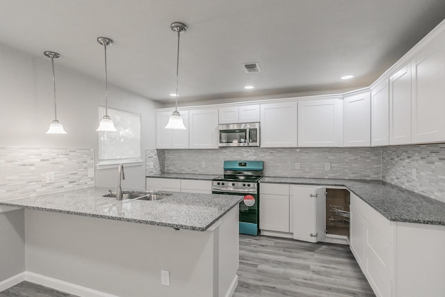 kitchen featuring decorative light fixtures, sink, white cabinets, kitchen peninsula, and stainless steel appliances