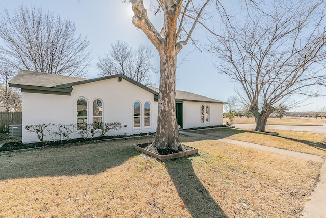 view of front of property featuring cooling unit and a front lawn