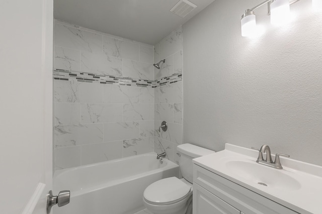 full bathroom featuring tiled shower / bath, vanity, and toilet