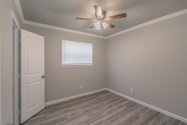 empty room featuring ornamental molding, ceiling fan, and light wood-type flooring