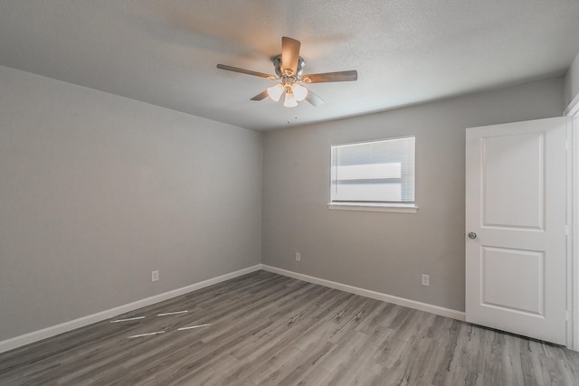 unfurnished room featuring a textured ceiling, wood-type flooring, and ceiling fan