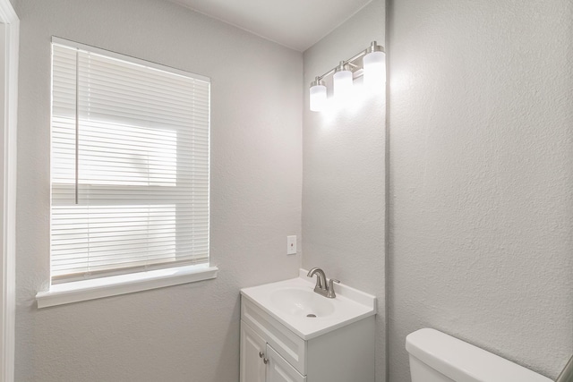 bathroom featuring a healthy amount of sunlight, toilet, and vanity