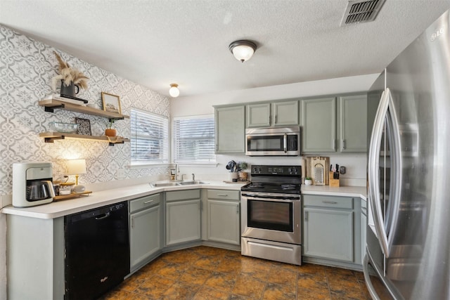 kitchen featuring stainless steel appliances, sink, and a textured ceiling