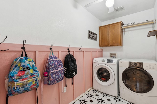 clothes washing area featuring ceiling fan, cabinets, and separate washer and dryer