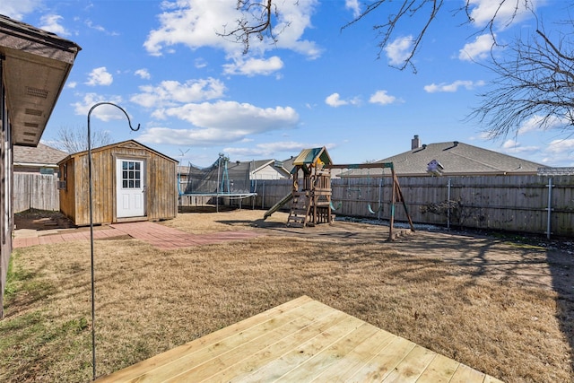 view of yard featuring a trampoline, a storage shed, and a playground