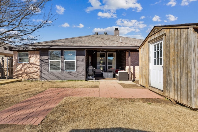 rear view of house featuring an outdoor living space, a patio area, and a lawn