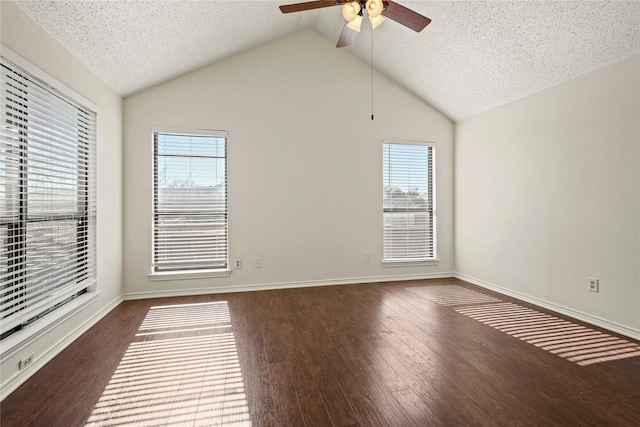 empty room featuring lofted ceiling, dark hardwood / wood-style floors, and a textured ceiling