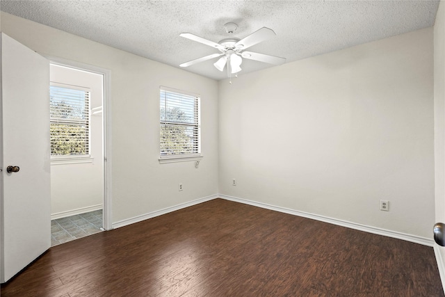 empty room with a textured ceiling, dark hardwood / wood-style floors, and ceiling fan