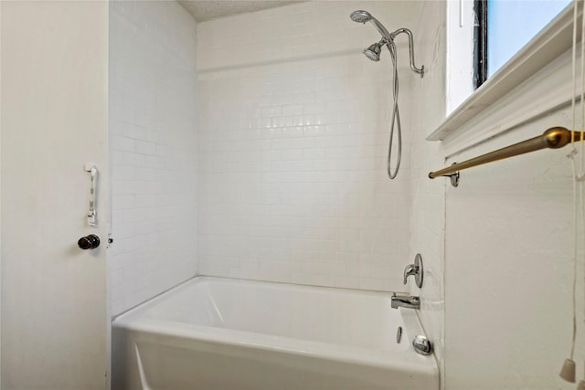 bathroom featuring tiled shower / bath and a textured ceiling