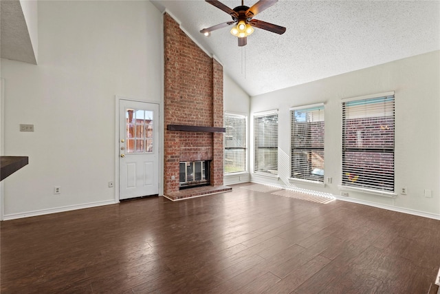 unfurnished living room featuring high vaulted ceiling, a textured ceiling, dark hardwood / wood-style flooring, ceiling fan, and a fireplace