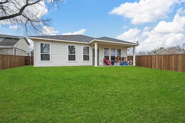 back of house with a yard and a patio