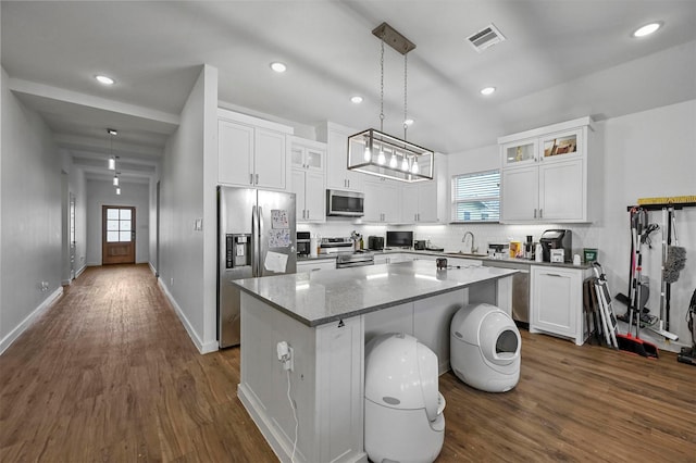 kitchen featuring pendant lighting, a center island, white cabinets, and appliances with stainless steel finishes