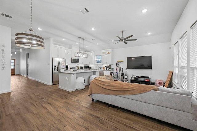 living room featuring sink, plenty of natural light, dark hardwood / wood-style floors, and ceiling fan with notable chandelier