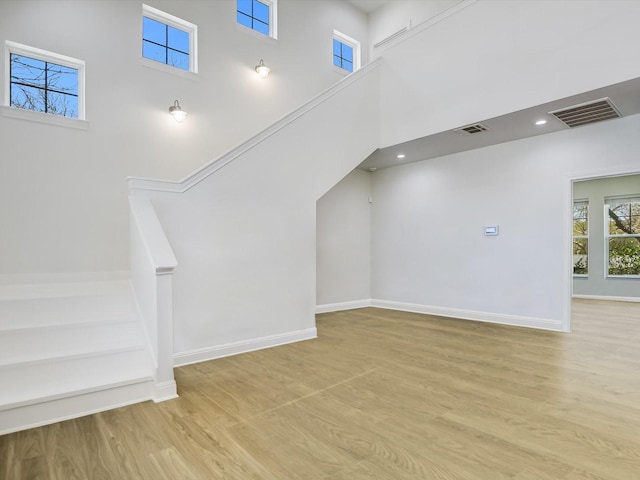 bonus room featuring a high ceiling and light hardwood / wood-style flooring