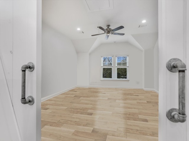 additional living space featuring vaulted ceiling and light wood-type flooring