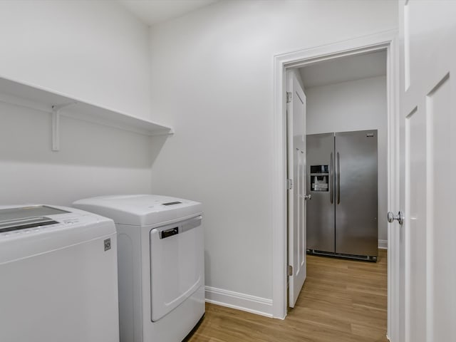 clothes washing area featuring washing machine and dryer and light hardwood / wood-style floors