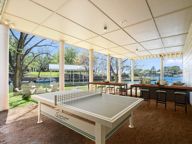 game room featuring a drop ceiling, carpet floors, and a water view