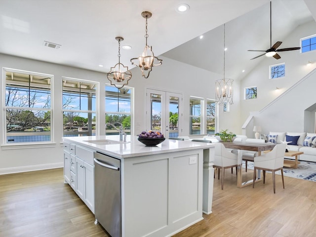 kitchen with sink, decorative light fixtures, dishwasher, an island with sink, and white cabinets