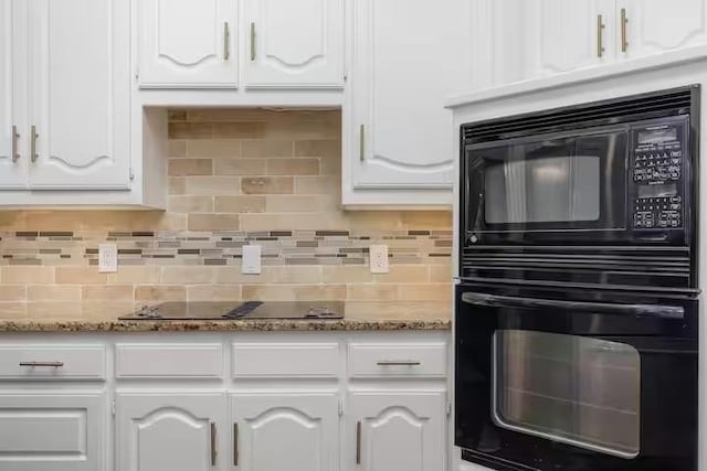 kitchen with tasteful backsplash, white cabinets, dark stone countertops, and black appliances